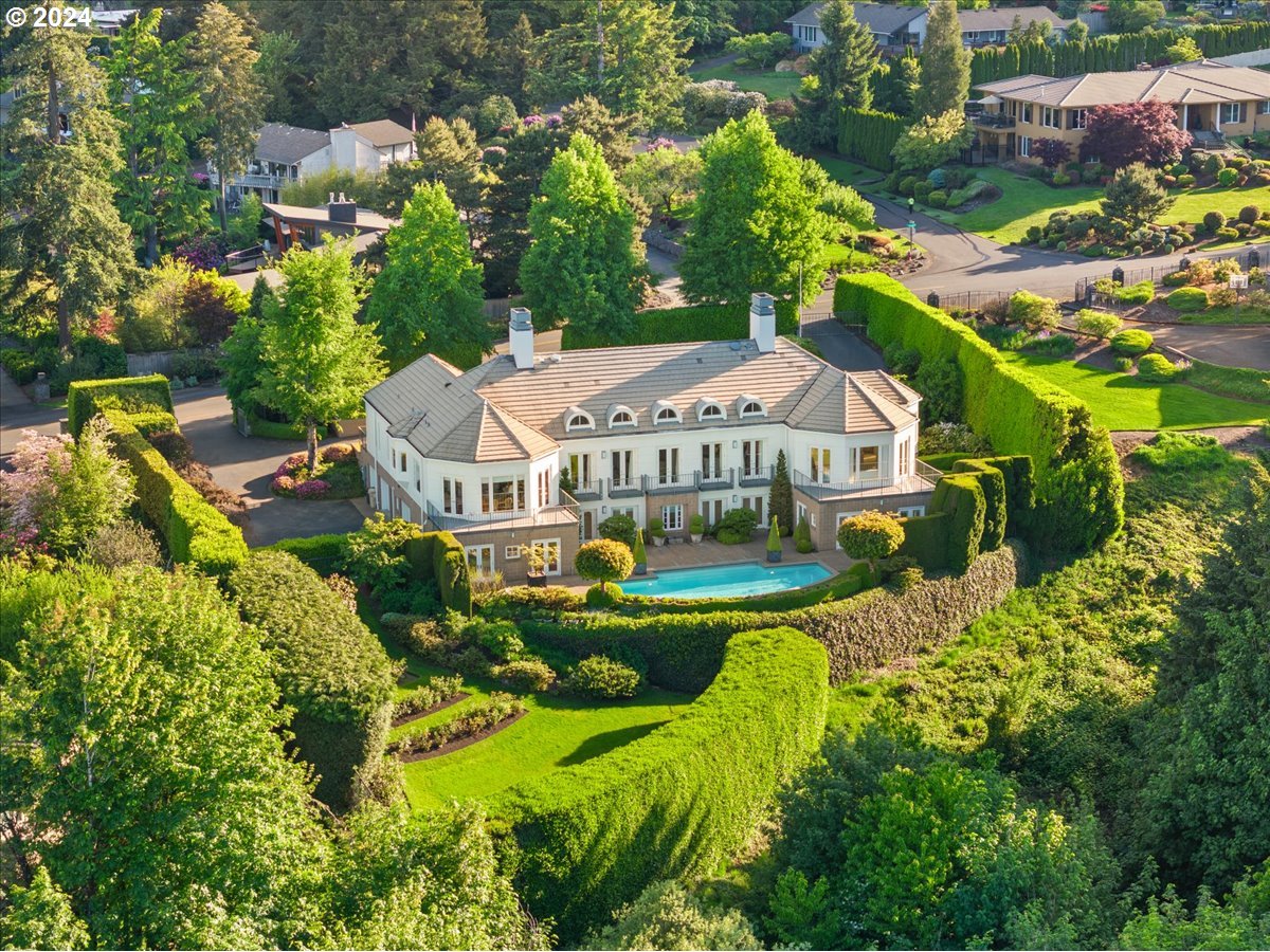 an aerial view of a house with a big yard and large trees