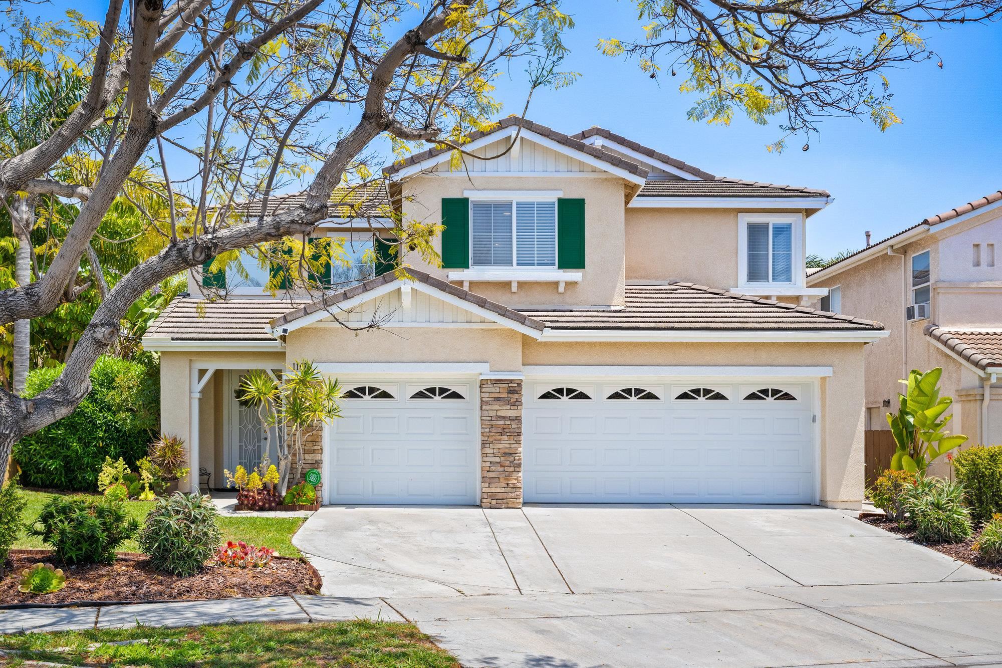 a front view of a house with a garden