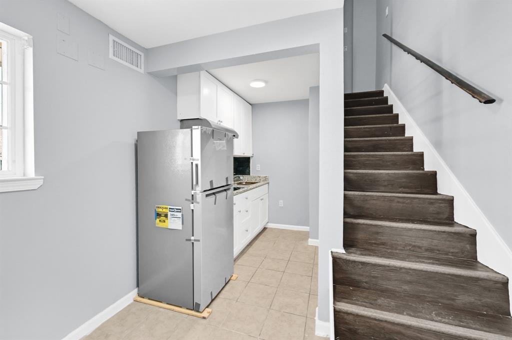 a view of kitchen with cabinets and refrigerator