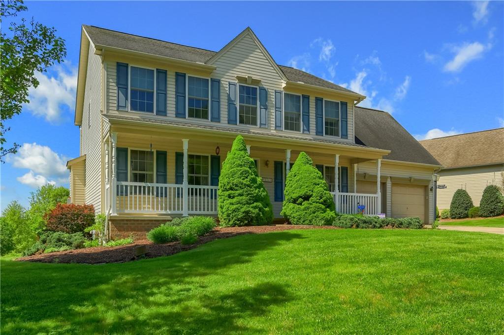 a front view of a house with a yard and potted plants