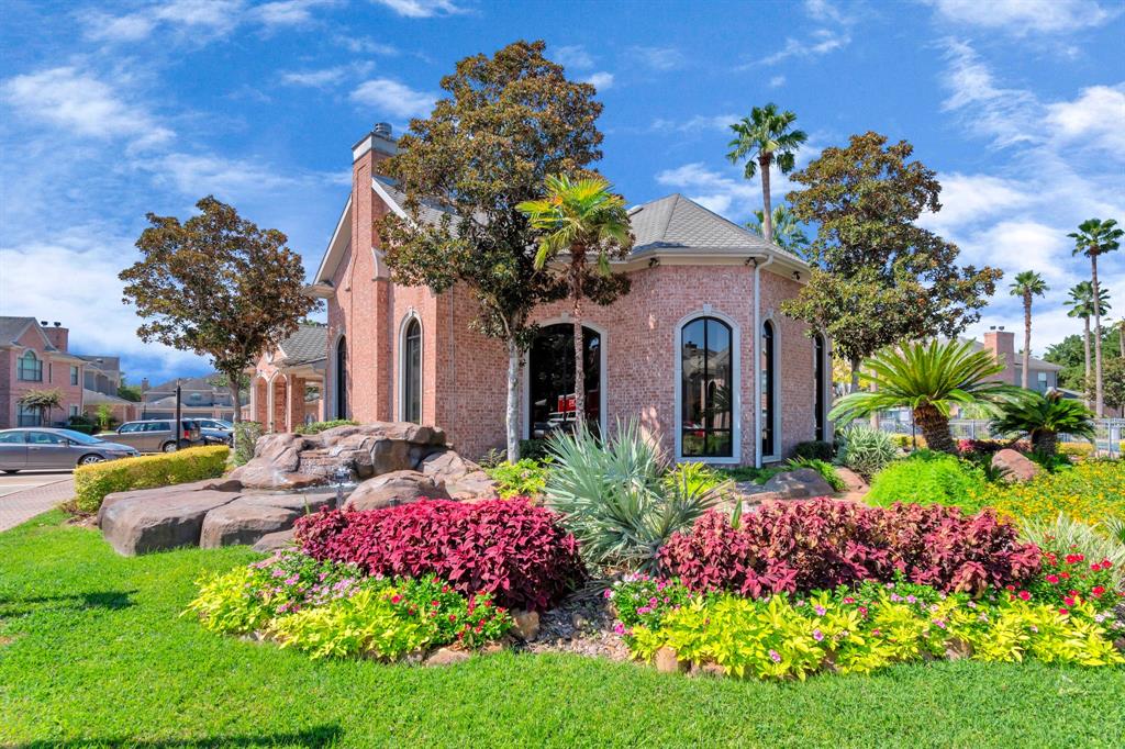 a front view of a house with a yard and fountain in middle