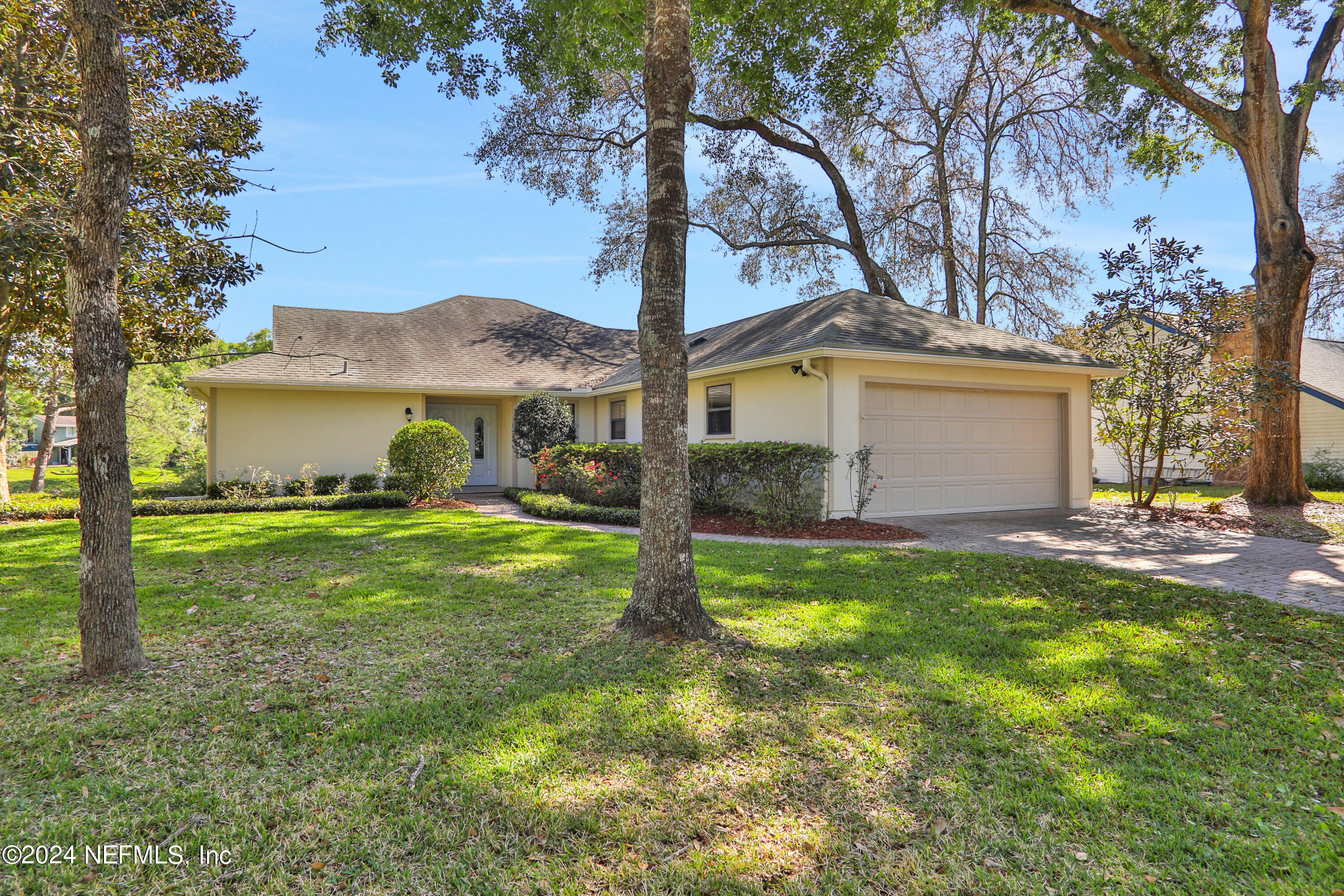 a view of a house with a yard and tree s