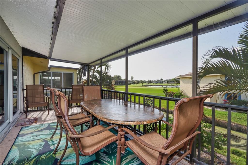 a balcony with furniture and a floor to ceiling window