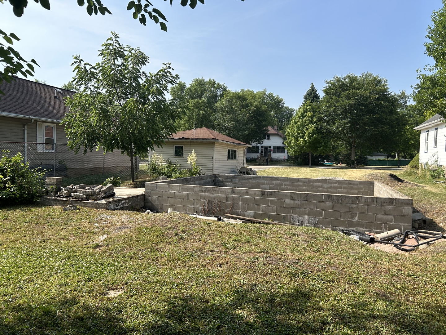 a view of swimming pool with lawn chairs and plants