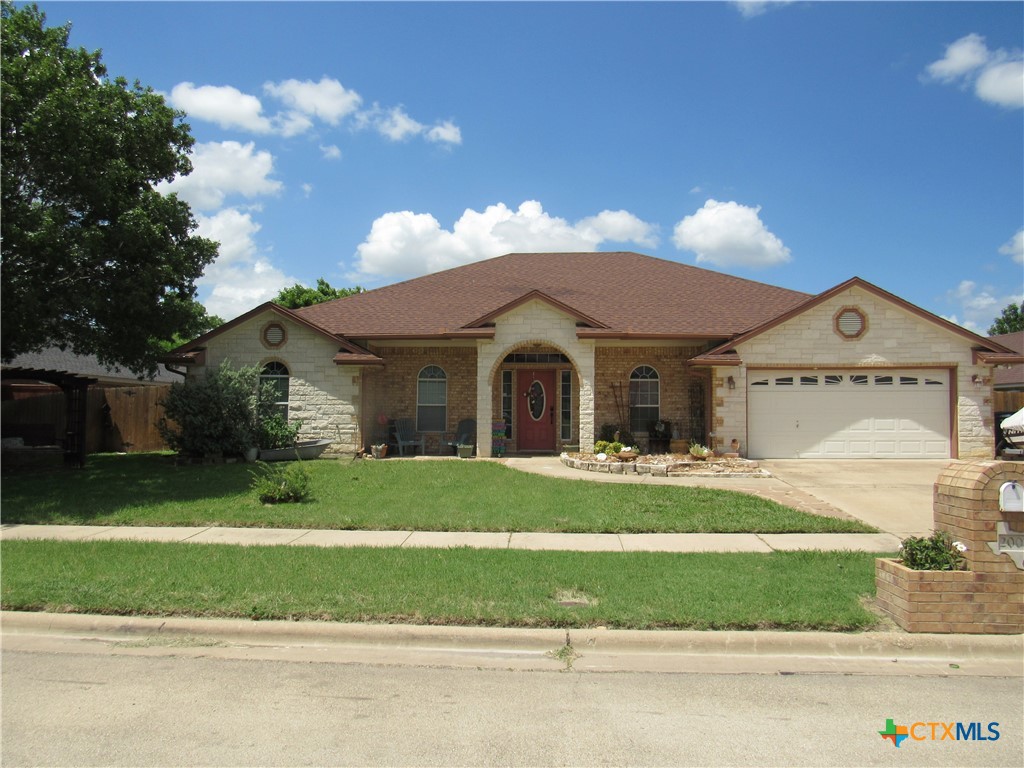 a front view of a house with a garden and yard