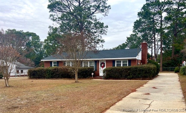 a front view of house with yard and trees around