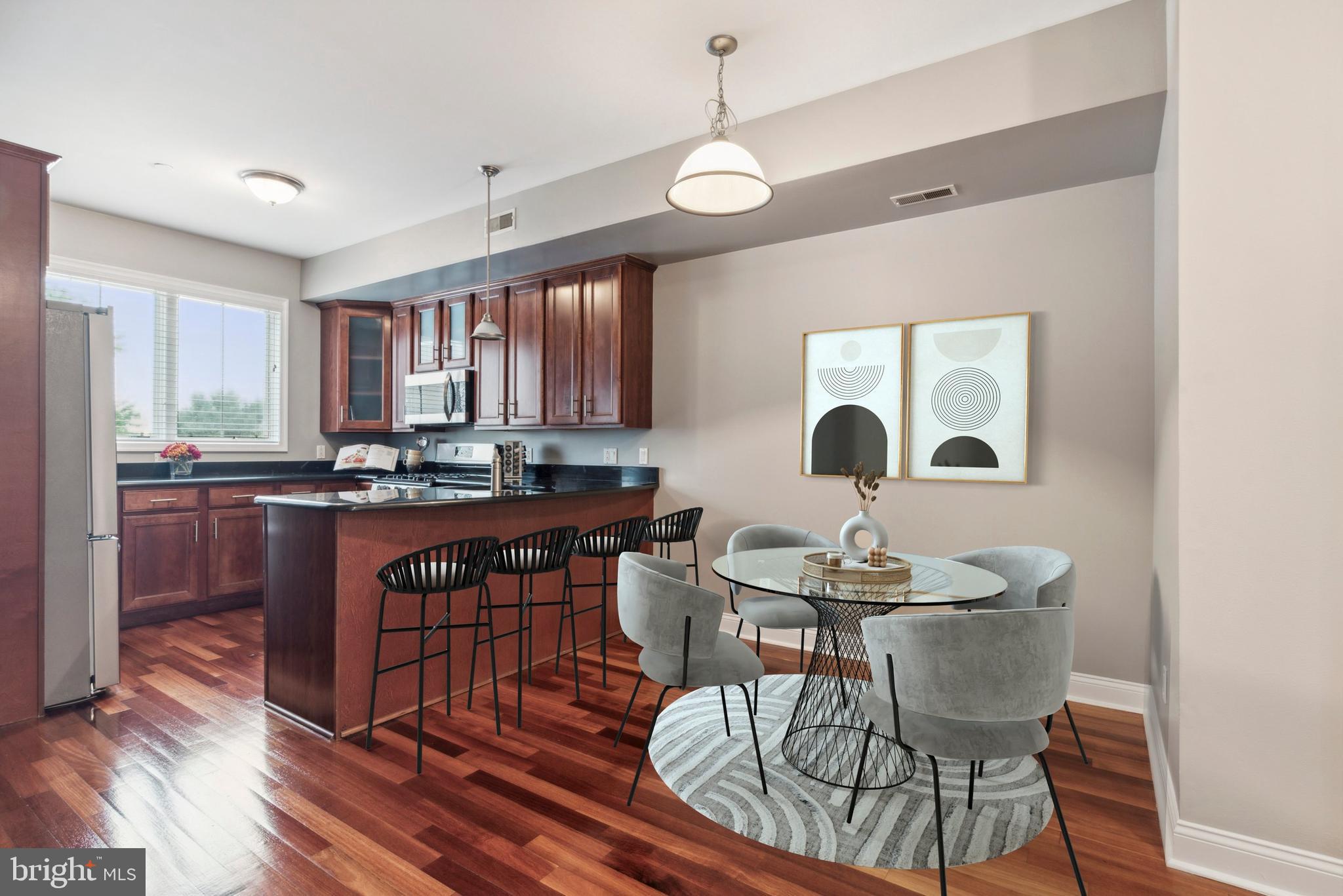 a kitchen with granite countertop a dining table chairs and a refrigerator