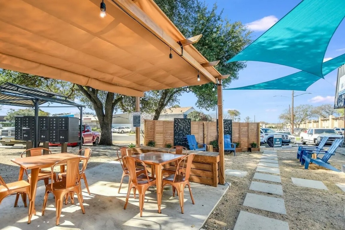 a view of a patio with dining table and chairs under an umbrella