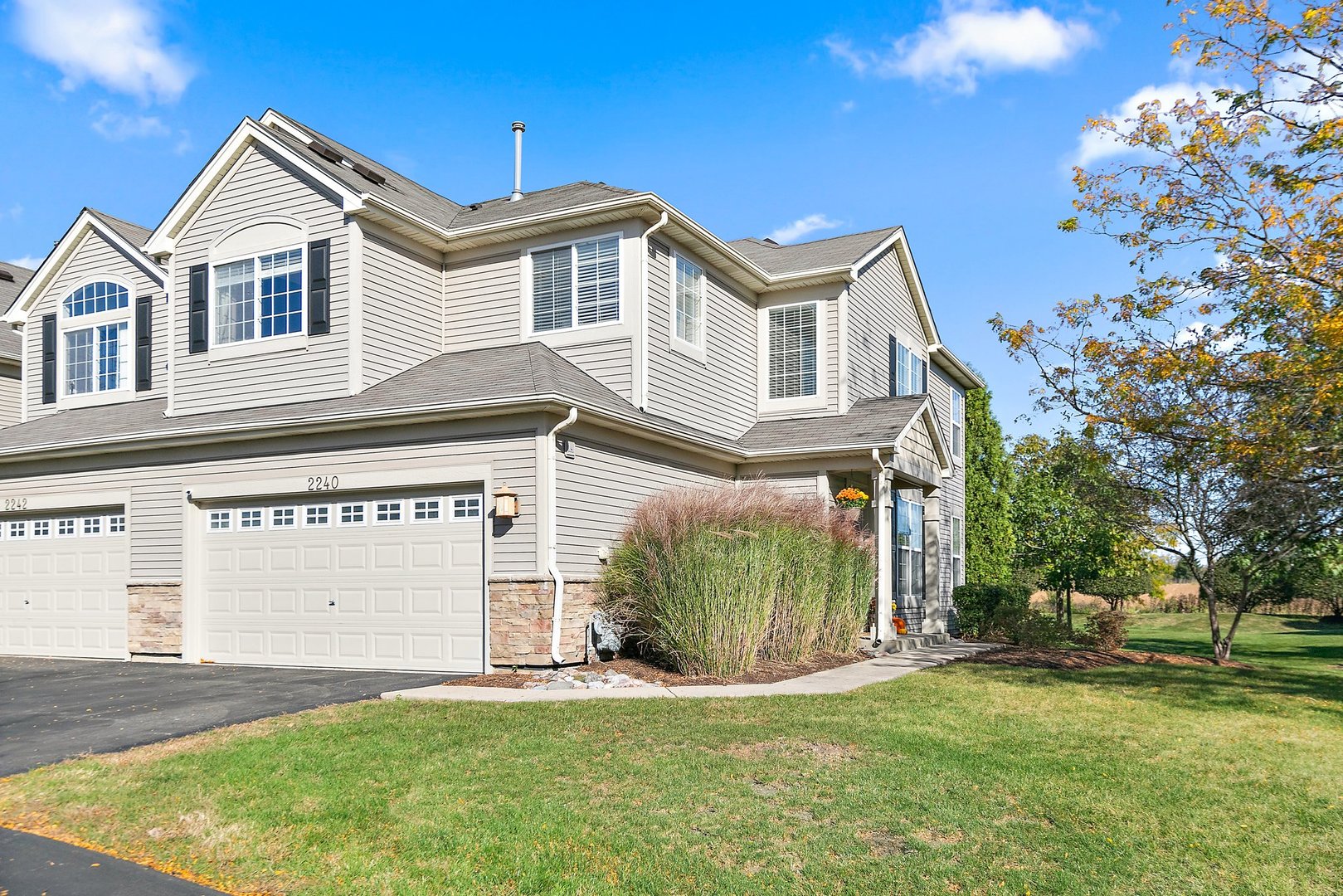 a front view of a house with a garden and garage