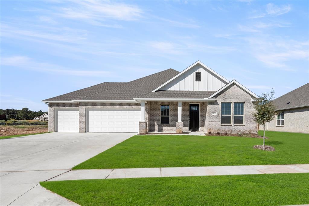 a front view of a house with a garden and yard