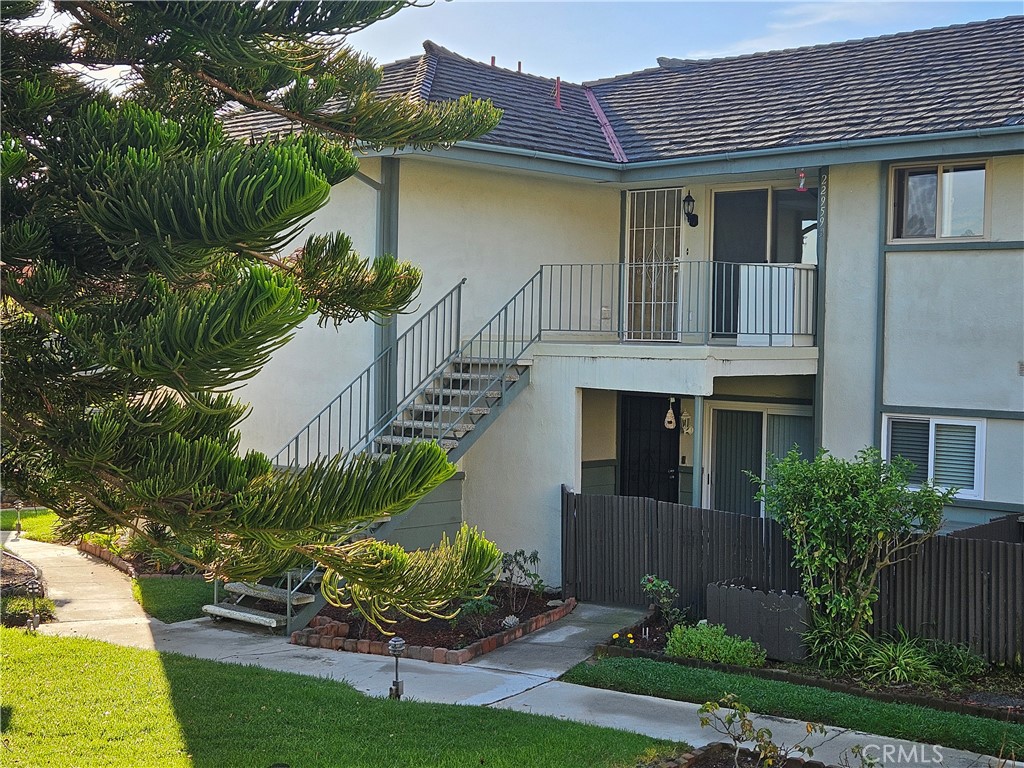 a front view of a house with a yard and potted plants