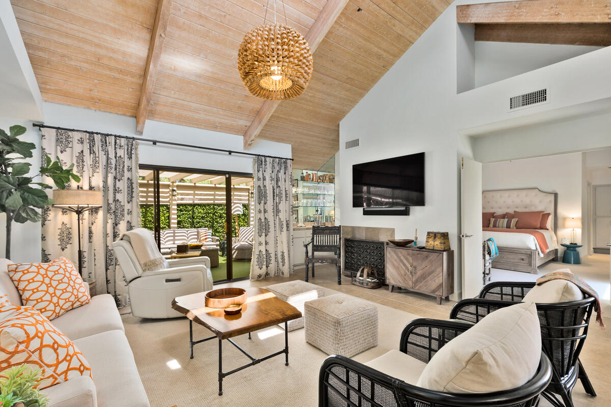 a living room with furniture a flat screen tv and a large window