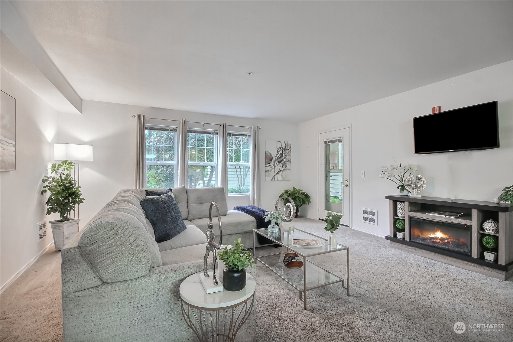 a living room with furniture a fireplace and a flat screen tv