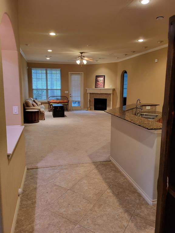 a large white kitchen with kitchen island a stove a sink a refrigerator and a counter top space