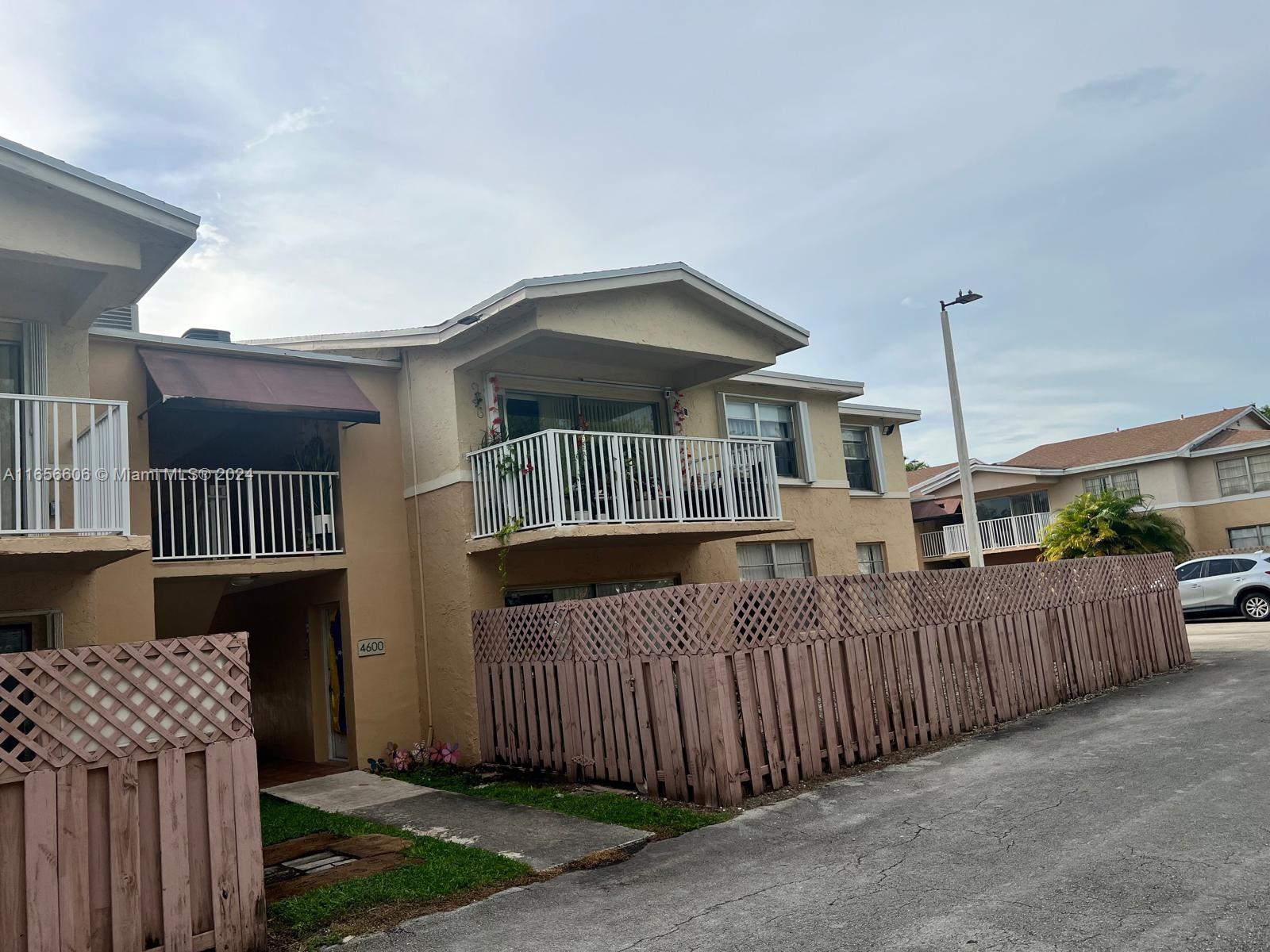 a view of a house with wooden fence