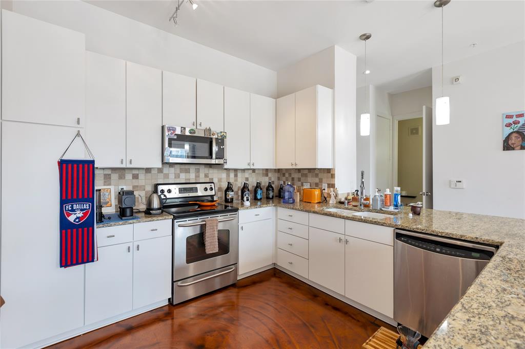 a kitchen with stainless steel appliances granite countertop a stove a sink and a microwave