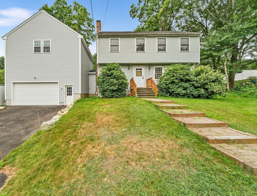 a view of a house with a yard and potted plants