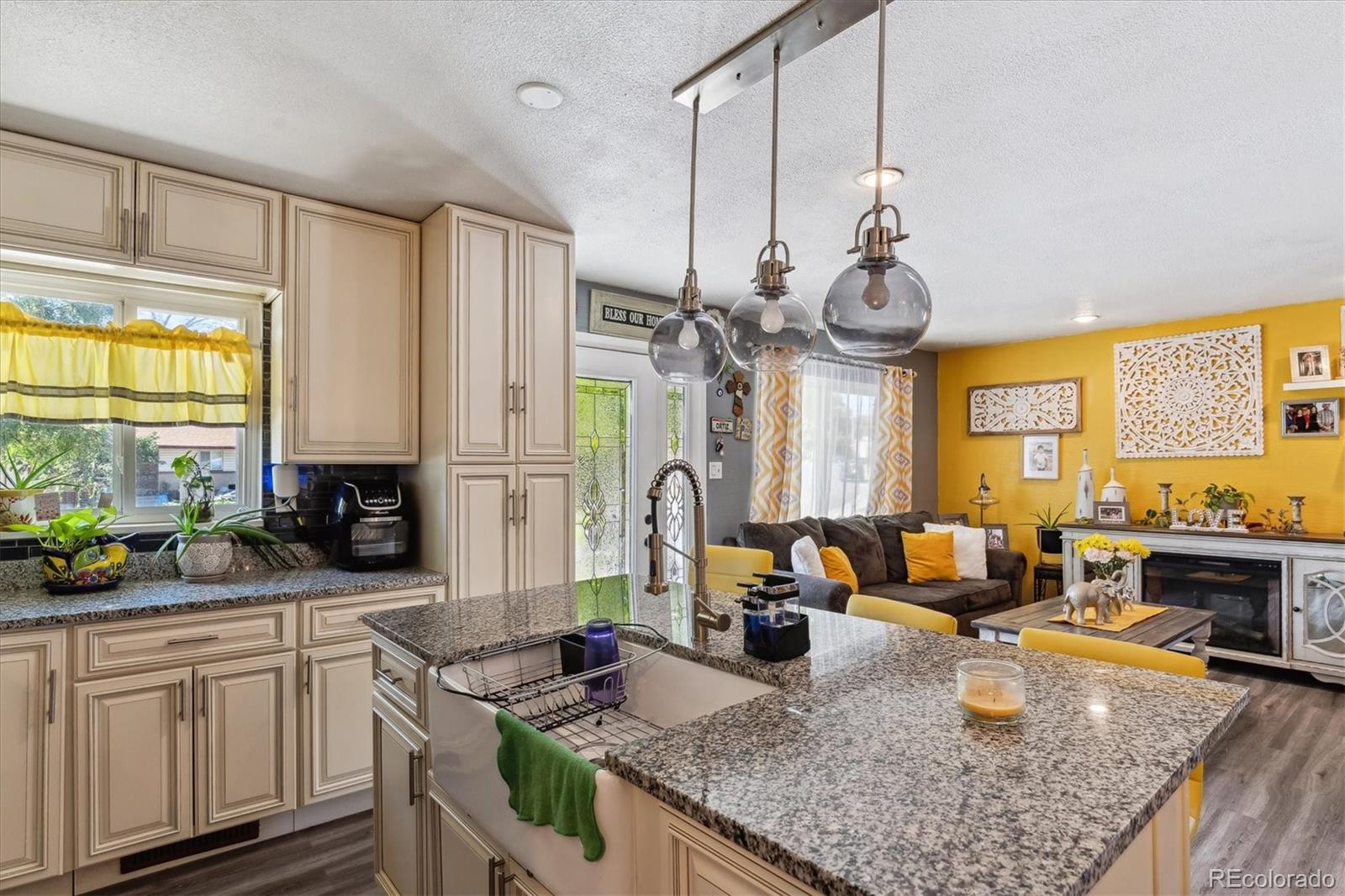 a kitchen with granite countertop a sink a stove and cabinets