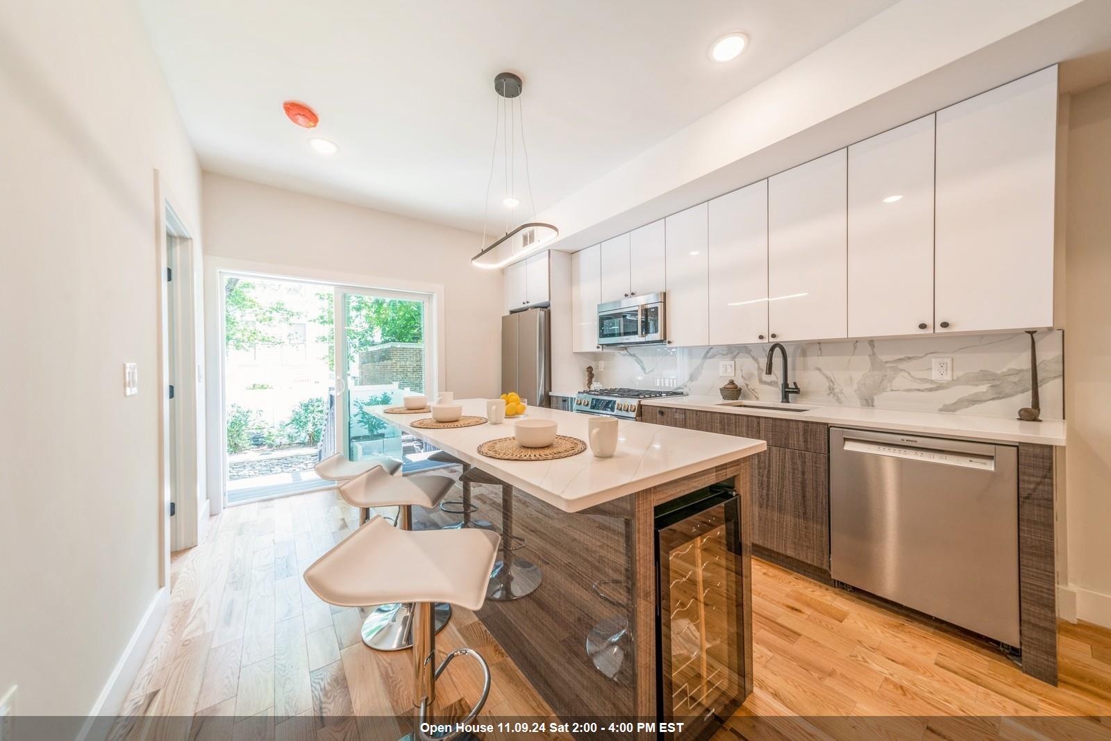 a kitchen with a sink a window and chairs