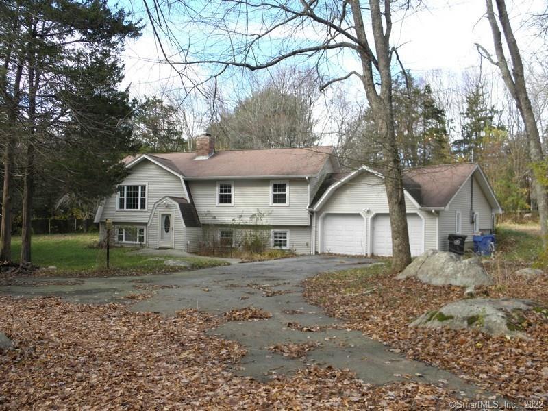 a view of a yard in front of a house with large trees