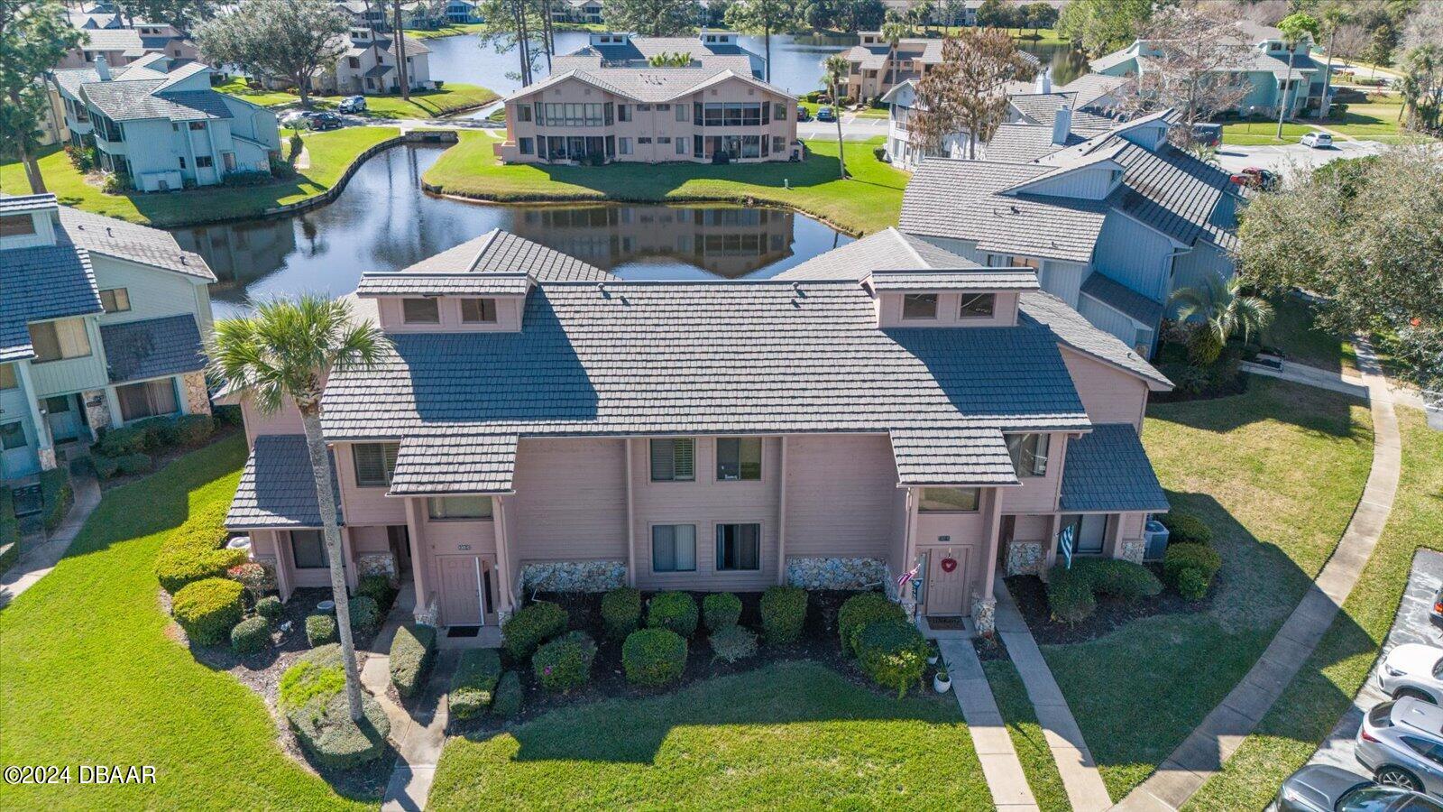 a aerial view of a house with swimming pool lawn chairs and a yard