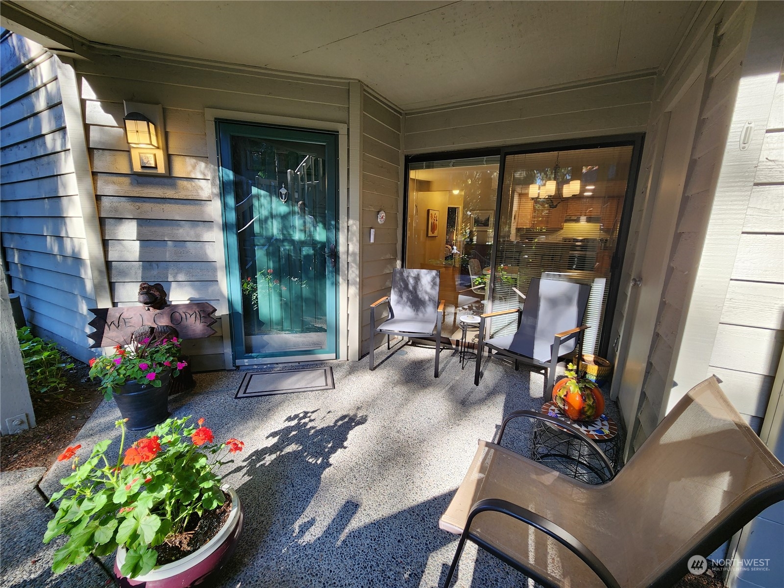 a view of a porch with chairs and potted plants