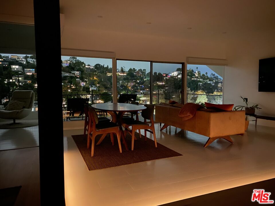 a living room with patio furniture and a floor to ceiling window