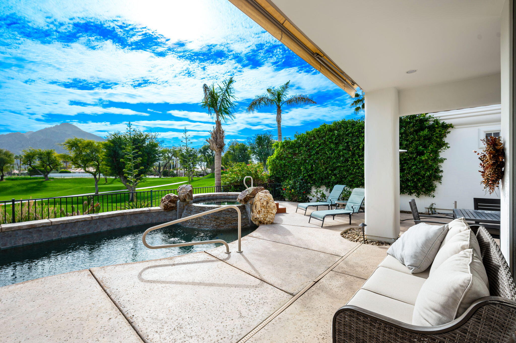 a view of a patio with couches potted plants and a big yard