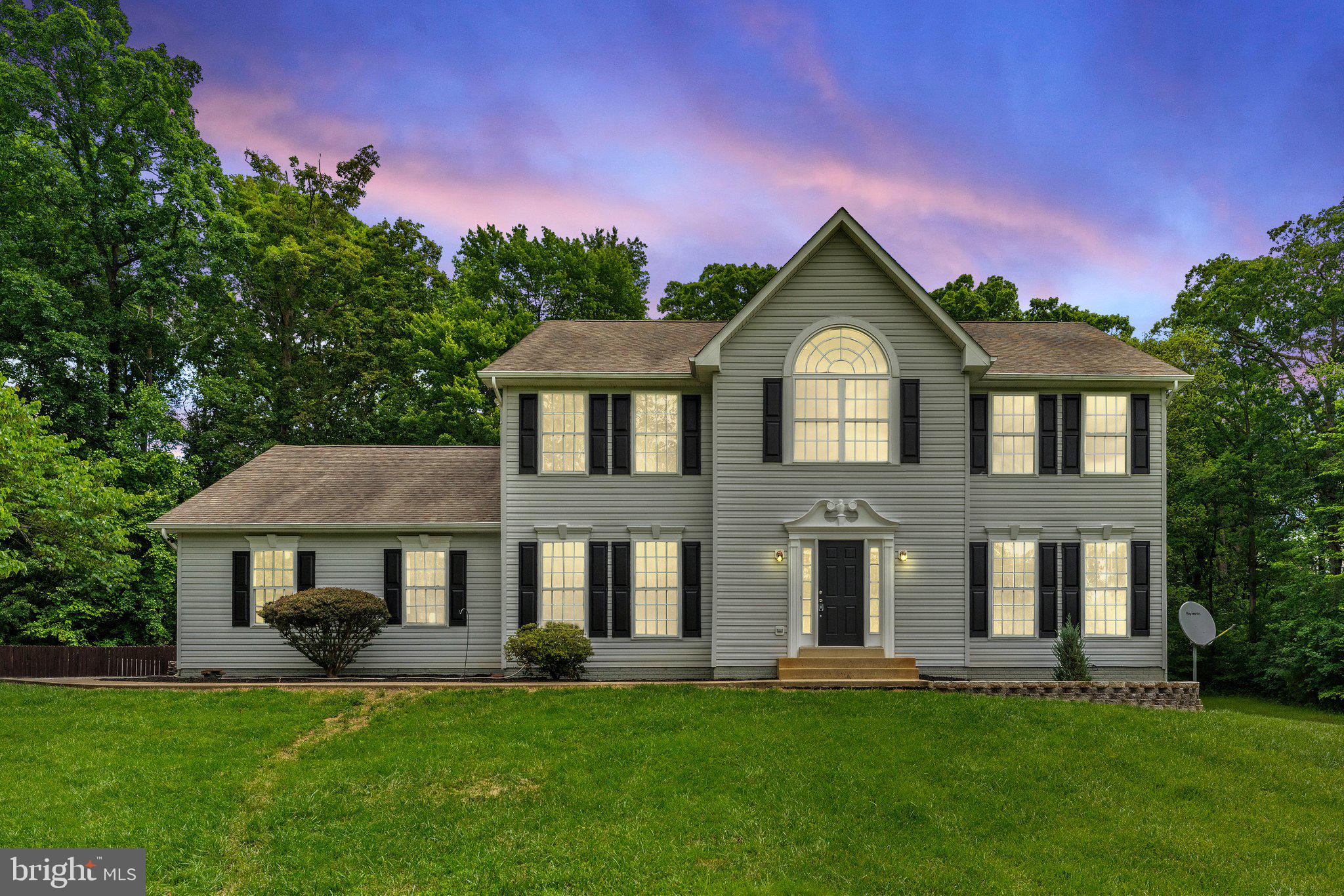 a front view of a house with a garden and yard