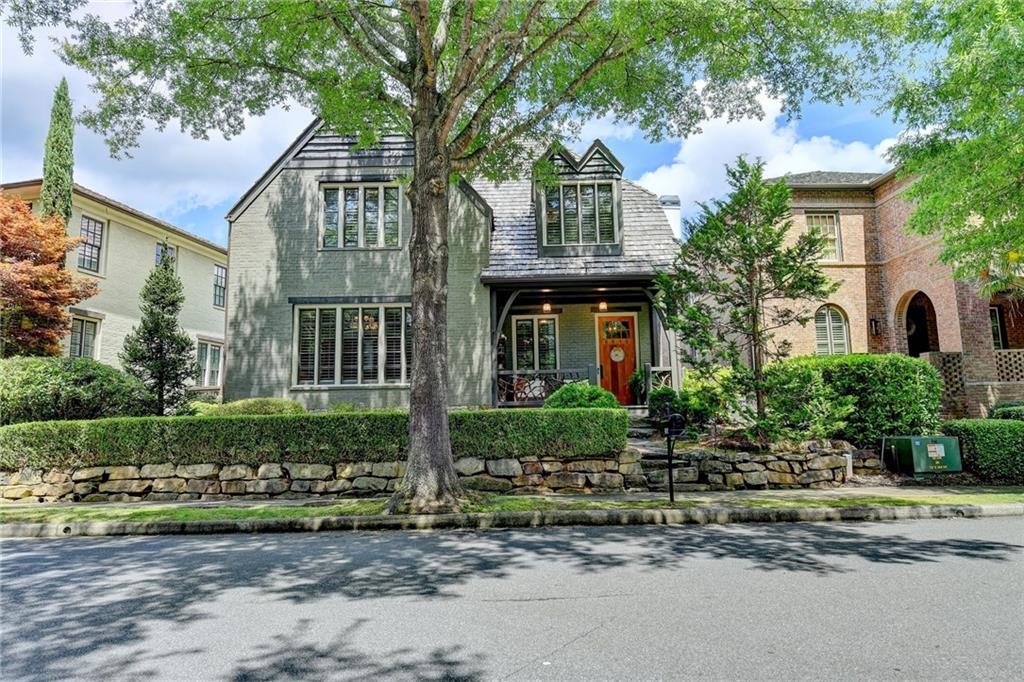 a front view of a house with a yard and potted plants