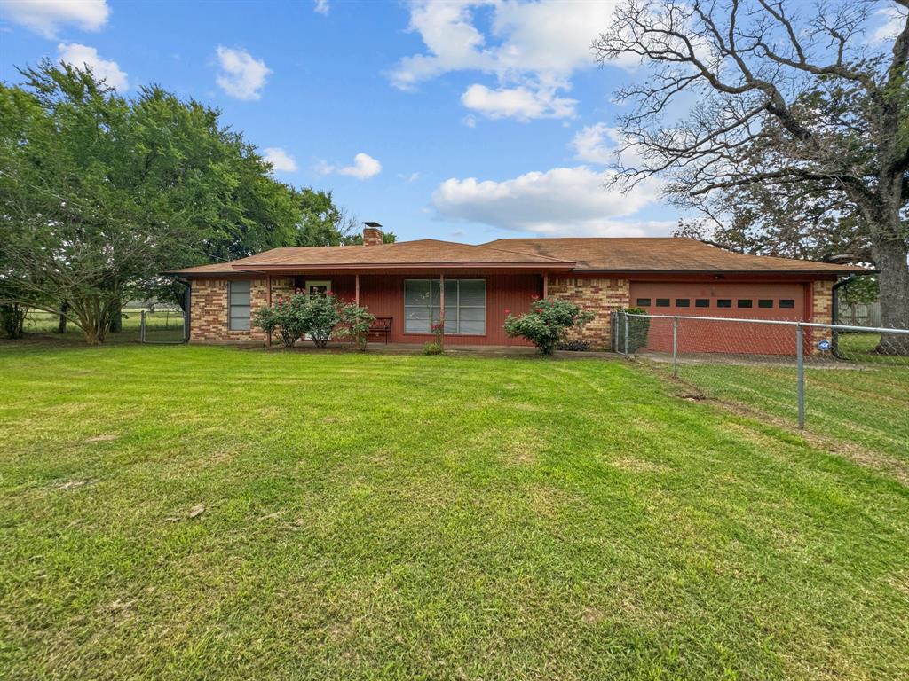 a view of a house with a big yard and large trees