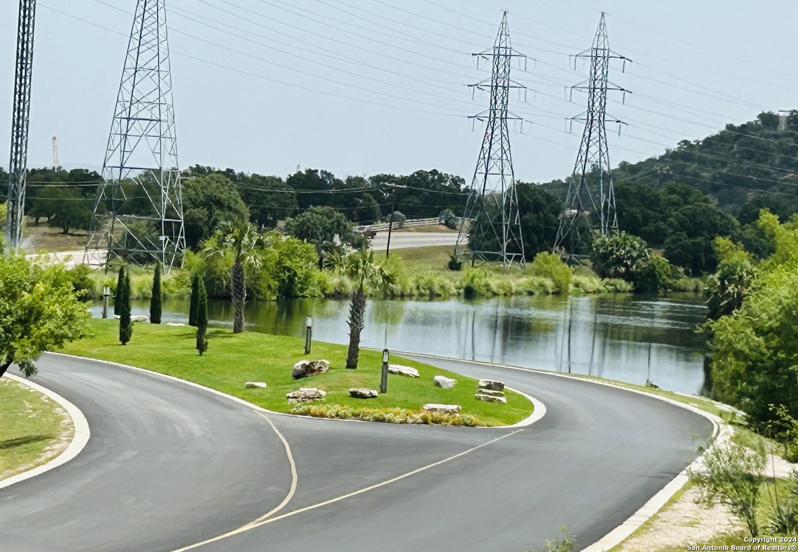 a view of a lake with a big yard and large trees