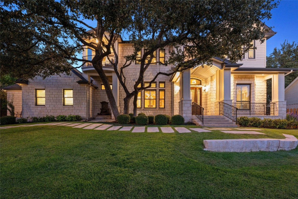 a view of a house with a big yard and large trees