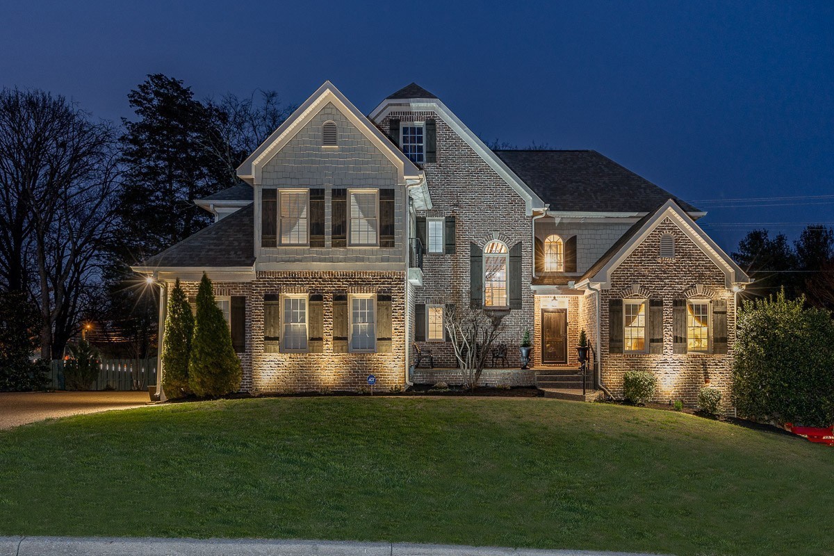 a front view of a house with a yard and trees