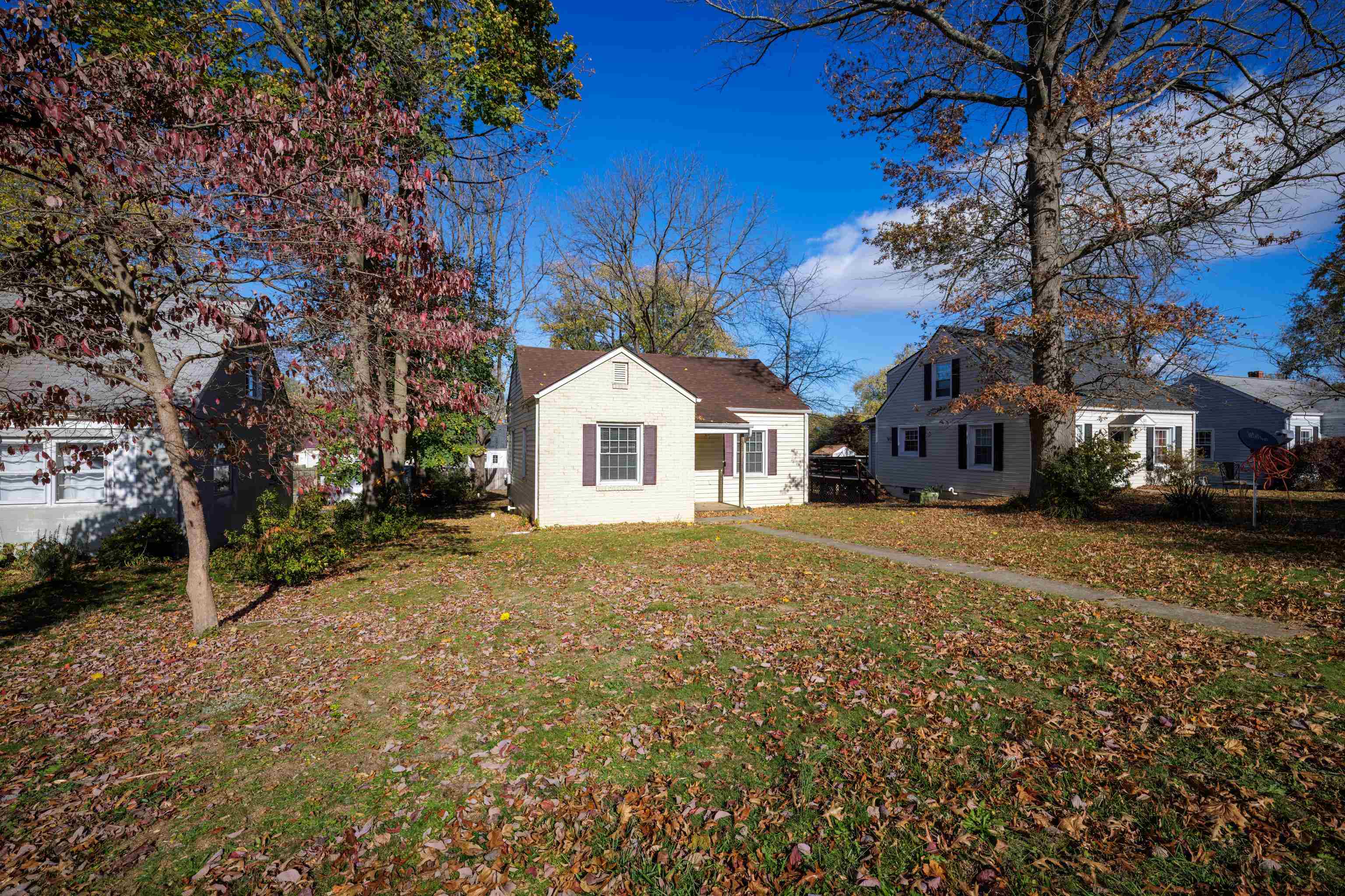 a view of a white house with a yard