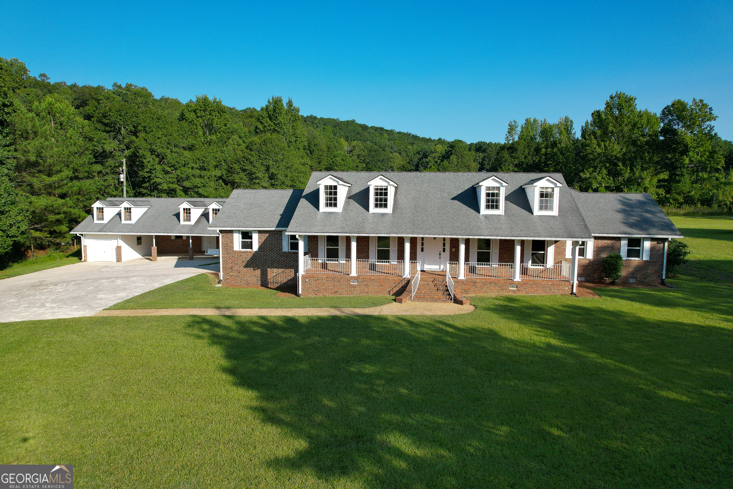 a aerial view of a house next to a big yard and large trees