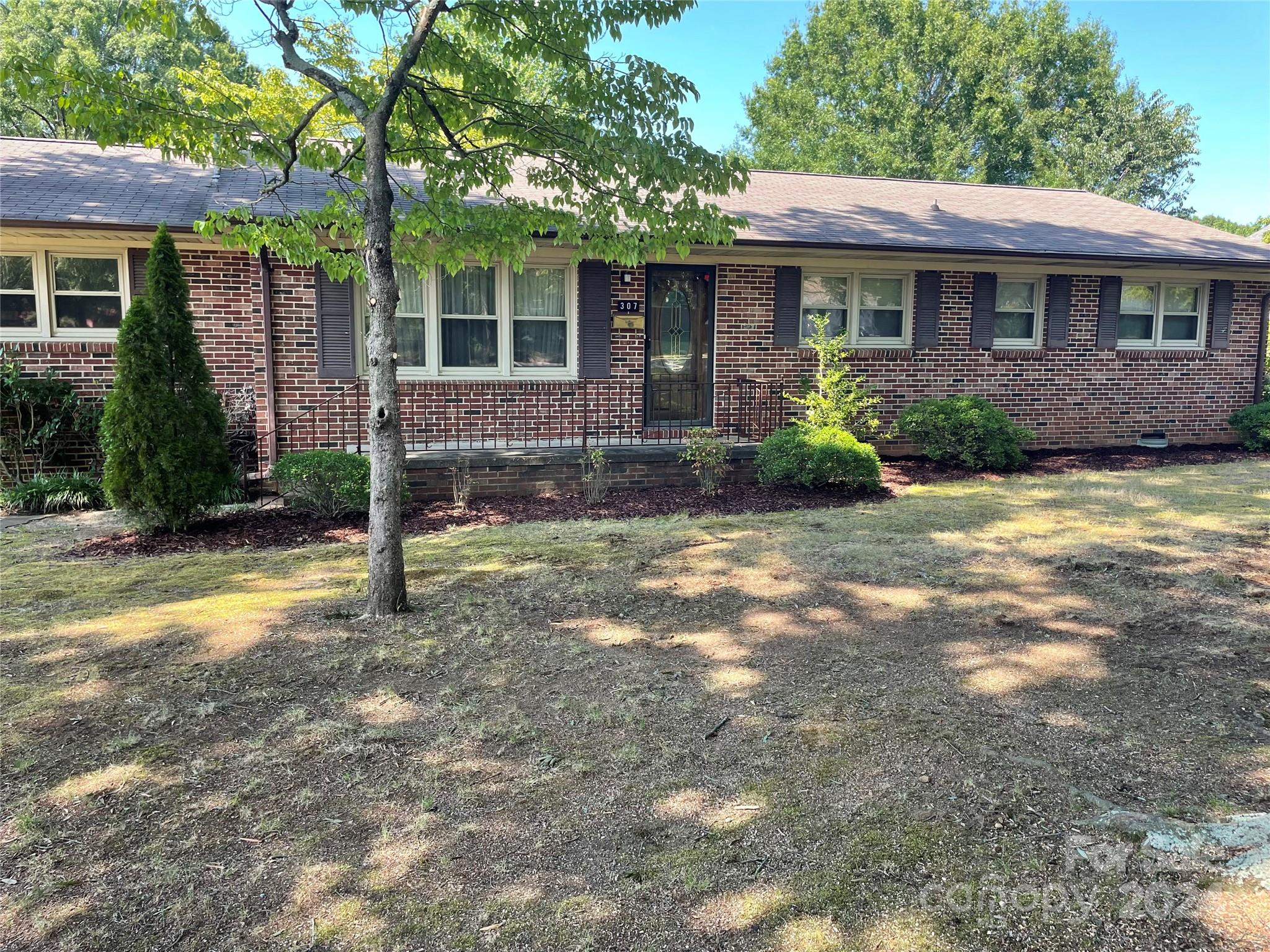 a view of a house with backyard and tree