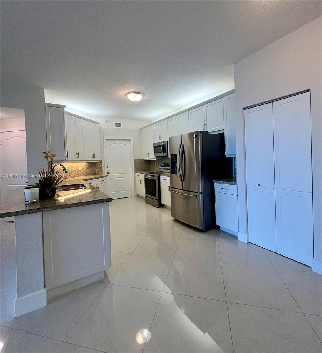 a kitchen with stainless steel appliances granite countertop a refrigerator and a stove top oven