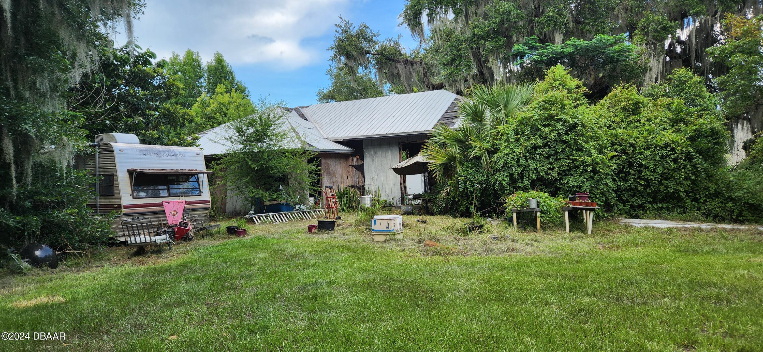 a view of a chair and table in backyard of the house