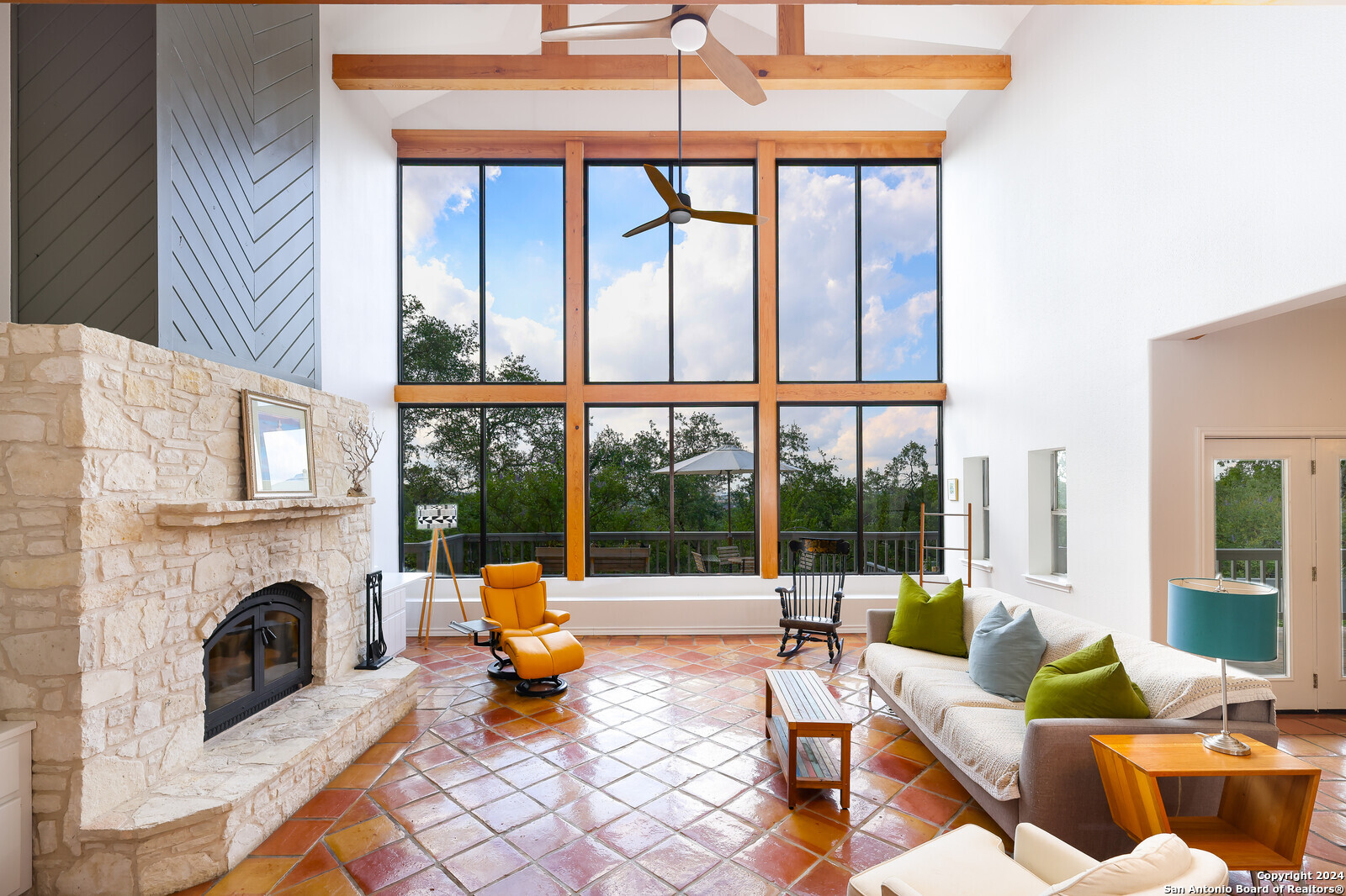 a living room with furniture a fireplace and a floor to ceiling window