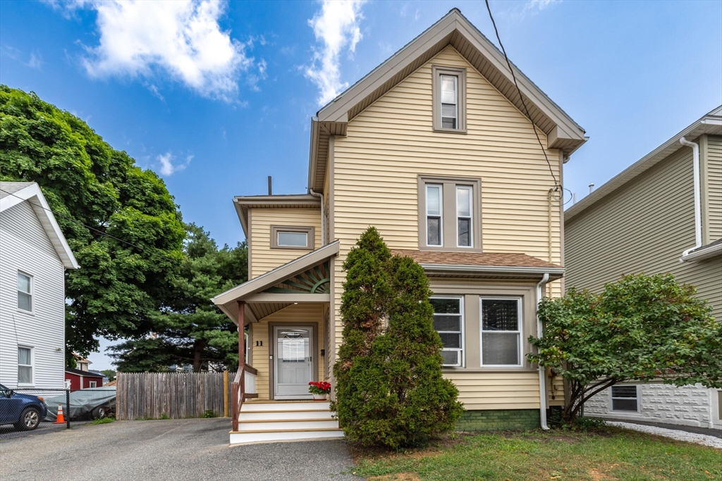 a view of a house with a yard and potted plants