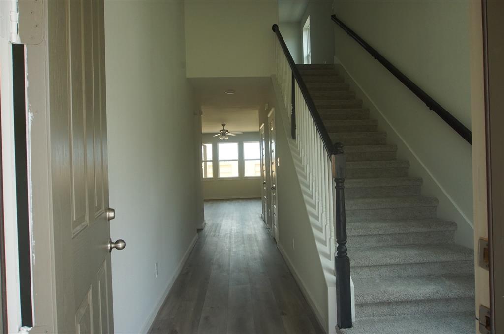 a view of staircase with wooden floor and white walls