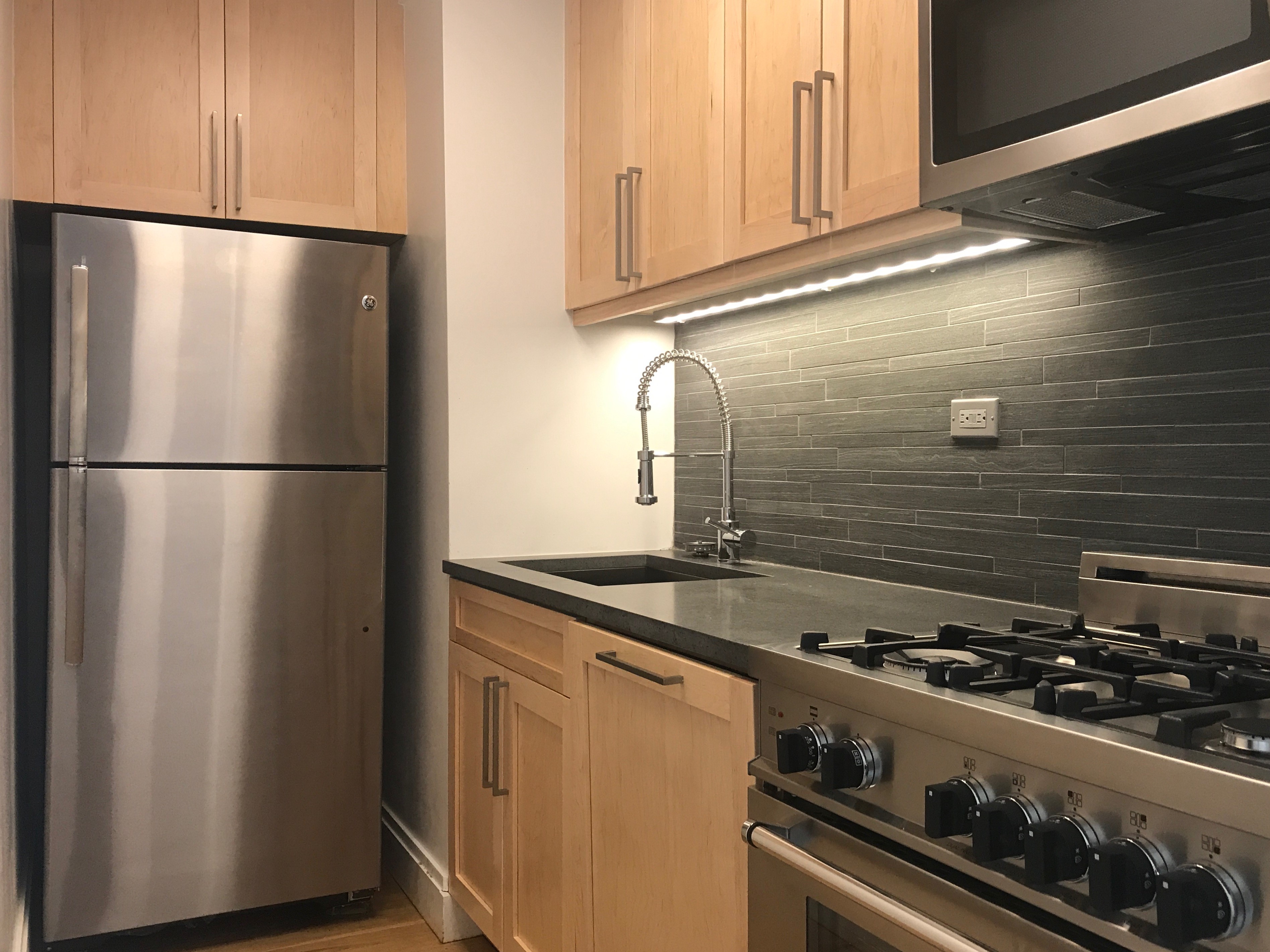 a kitchen with granite countertop a refrigerator and a stove