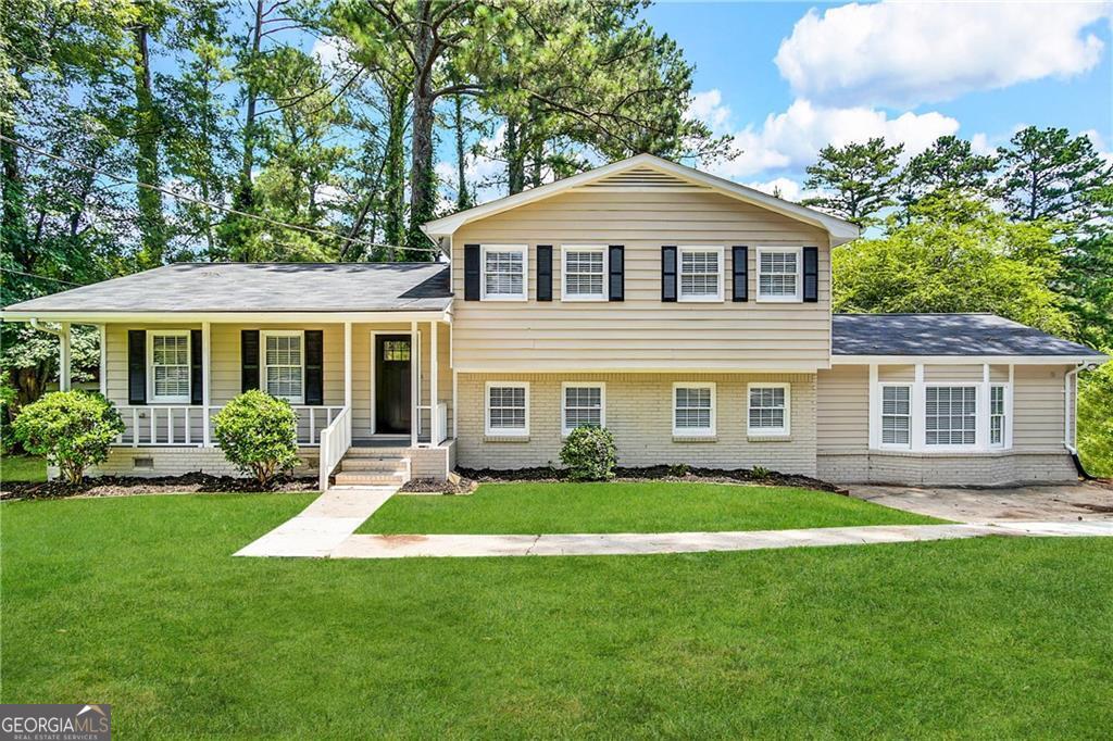 a front view of a house with a yard and green space