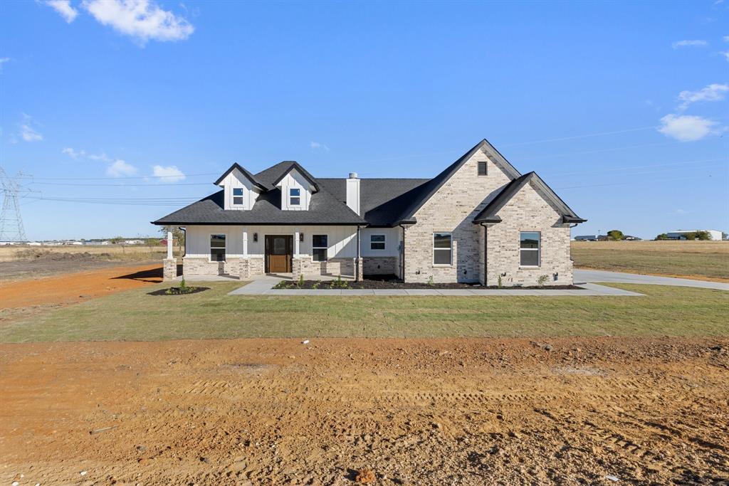 a front view of a house with a yard and ocean view