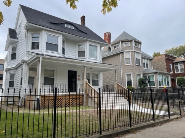 a front view of a house with a iron fence