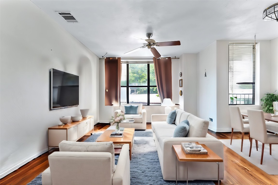 a living room with furniture fireplace and a large window