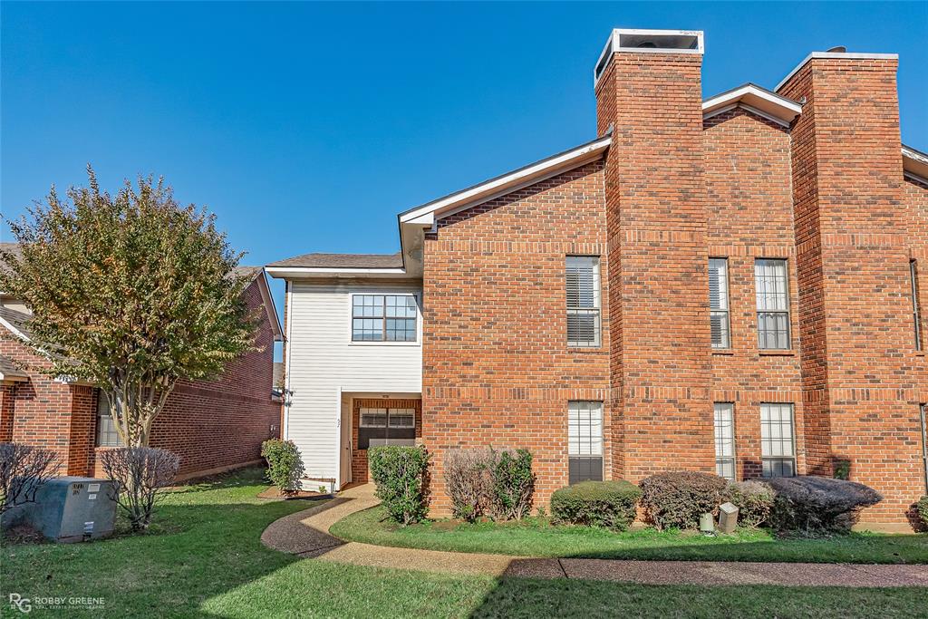 a brick building with a yard and windows