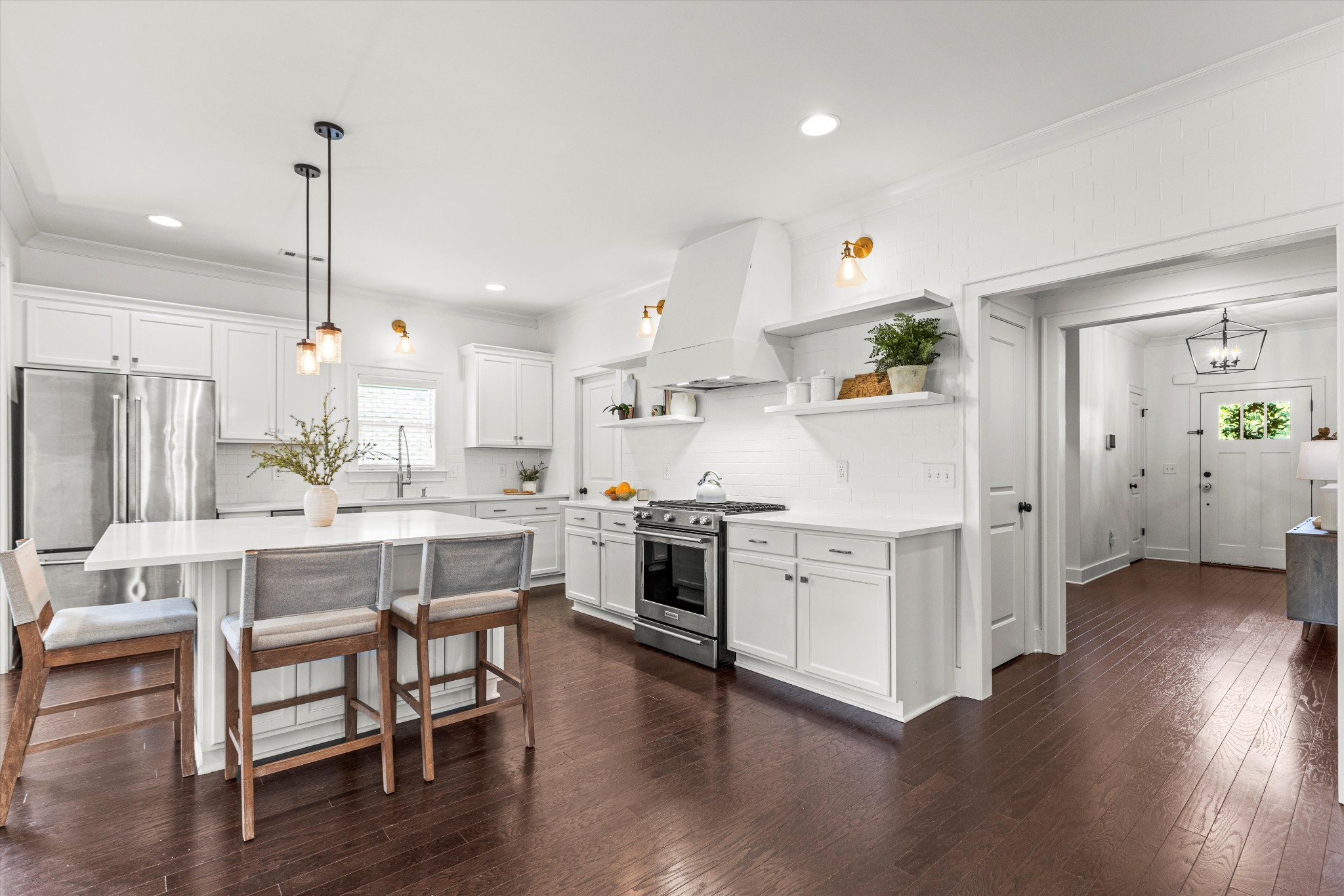 a kitchen with stainless steel appliances white cabinets and wooden floor