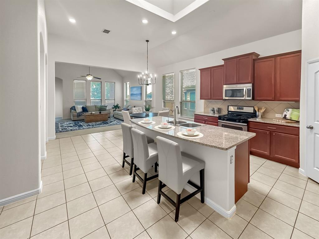 a kitchen with stainless steel appliances kitchen island granite countertop a sink and cabinets